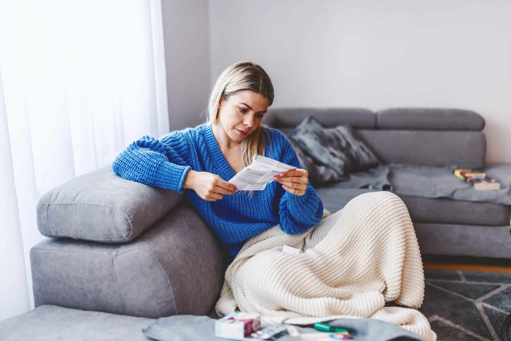 attractive,caucasian,blond,woman,sitting,on,sofa,in,living,room