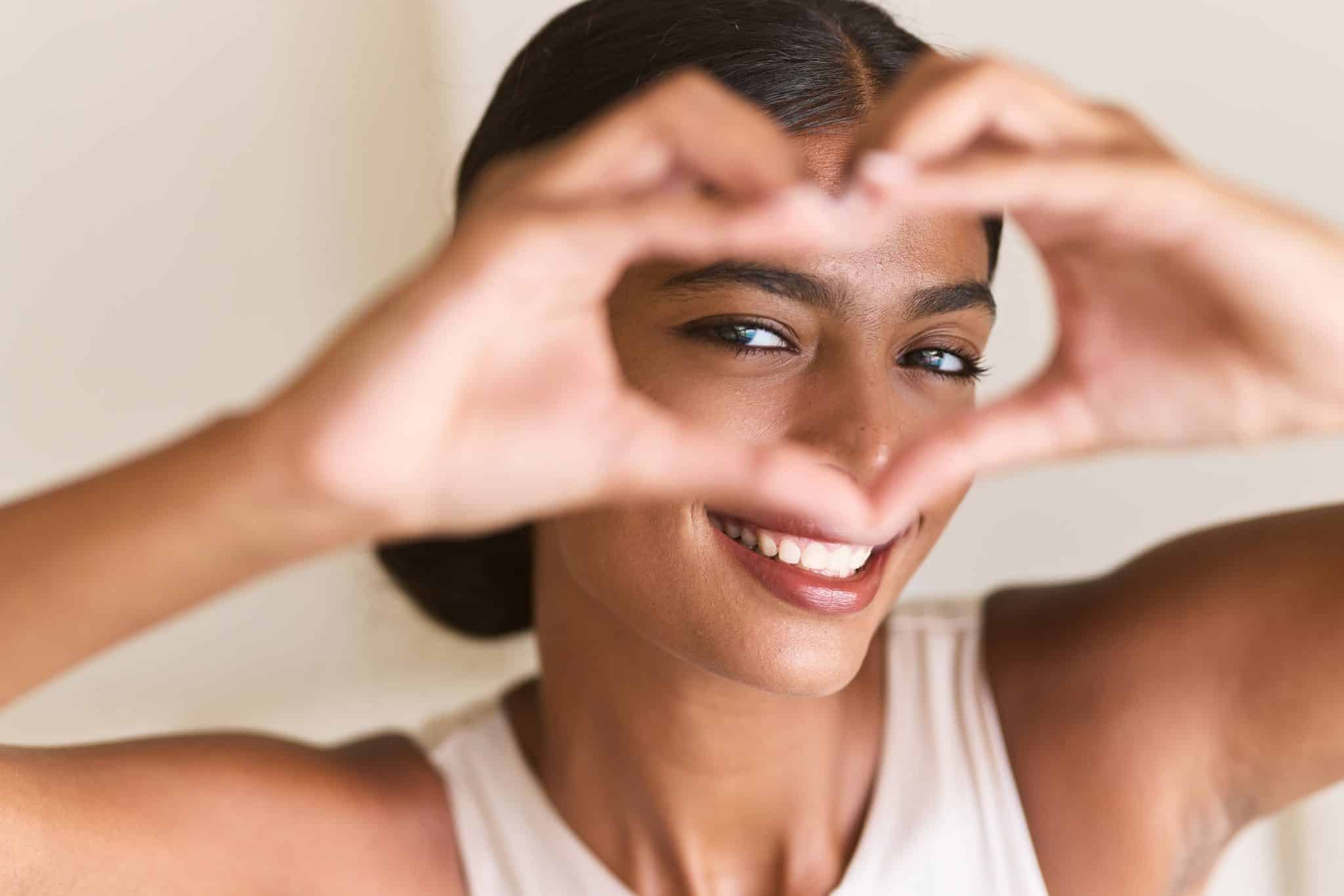 a,smiling,woman,framing,her,face,with,her,hands,in